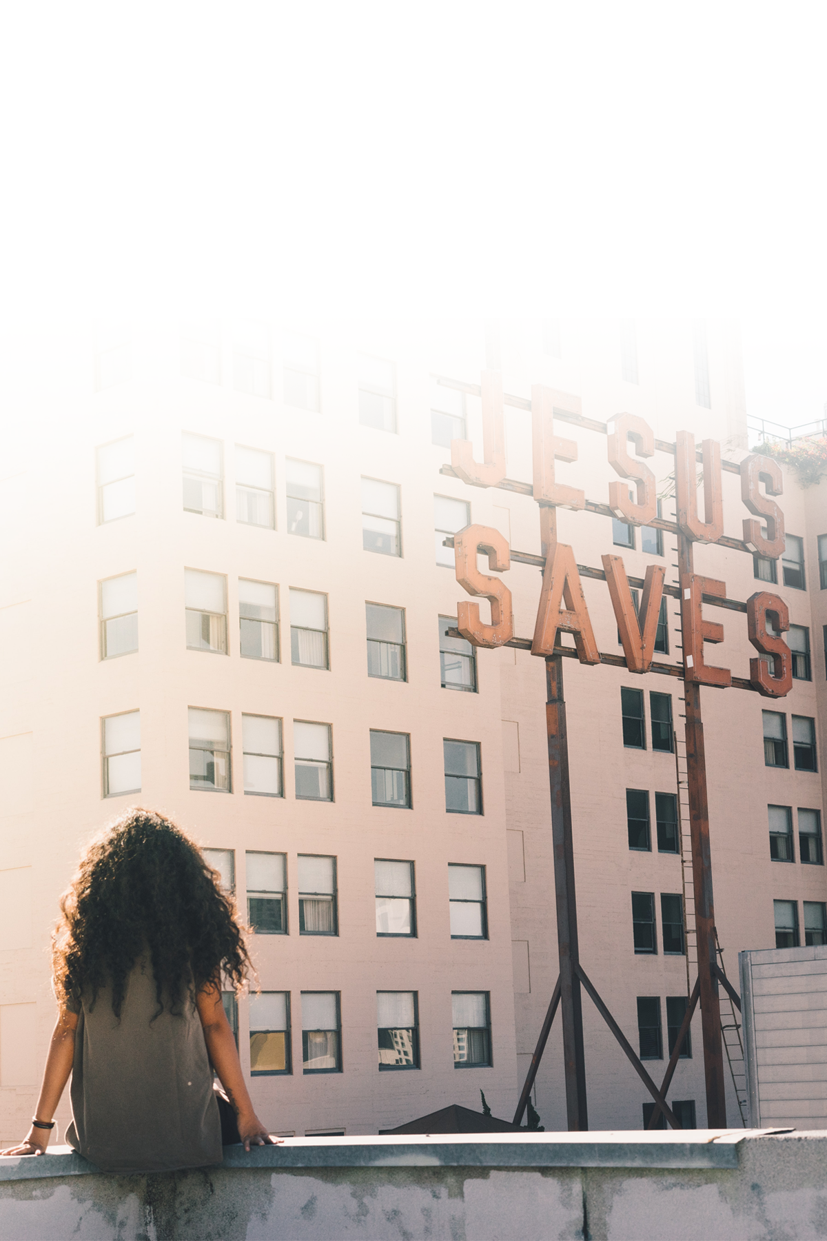 Woman looking at a Jesus Saves sign on a building